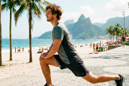 homem alongando na praia