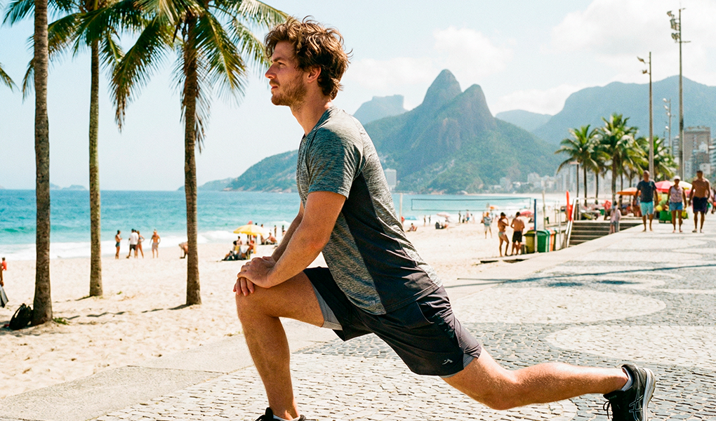 homem alongando na praia
